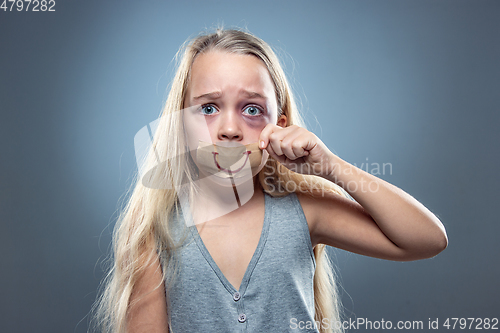 Image of Sad and frightened little girl with bloodshot and bruised eyes, fiction of happiness