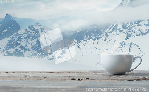 Image of Single tea or coffee mug and landscape of mountains on background