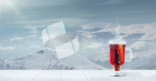 Image of Mulled wine and landscape of mountains on background