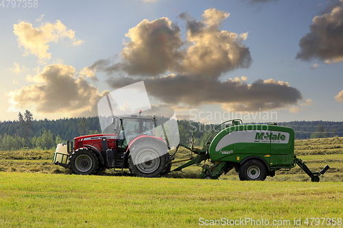 Image of Tractor and Baler Working in Evening Light
