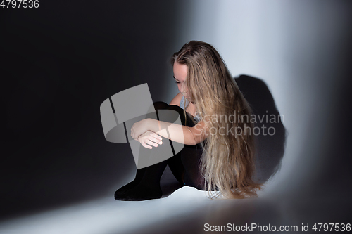 Image of Sad and frightened little girl with bloodshot and bruised eyes sitting scared