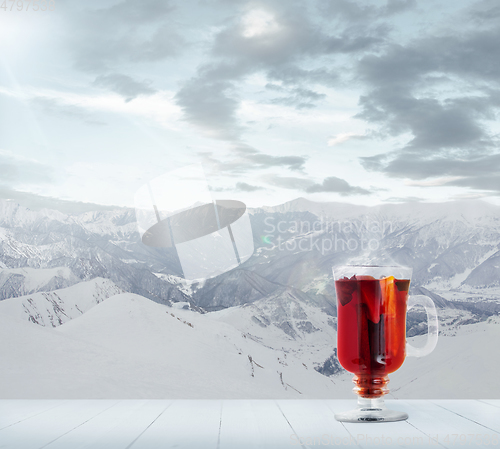 Image of Mulled wine and landscape of mountains on background