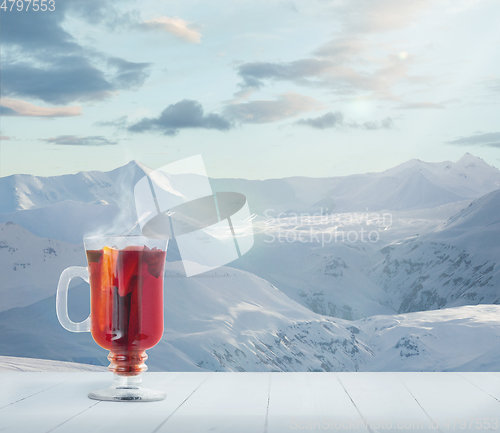 Image of Mulled wine and landscape of mountains on background