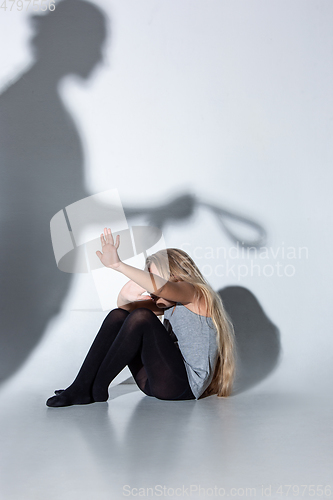 Image of Sad and frightened little girl with bloodshot and bruised eyes sitting scared