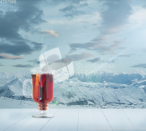 Image of Mulled wine and landscape of mountains on background