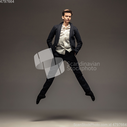 Image of Man in casual office style clothes jumping isolated on studio background