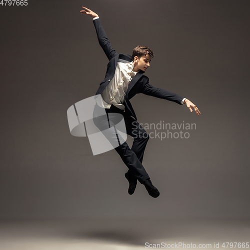 Image of Man in casual office style clothes jumping isolated on studio background