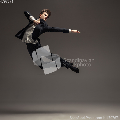 Image of Man in casual office style clothes jumping isolated on studio background