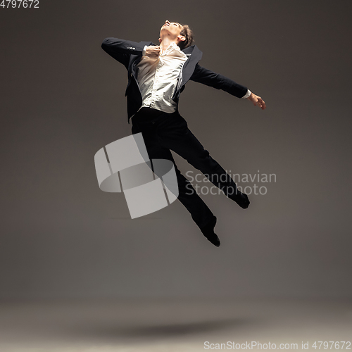 Image of Man in casual office style clothes jumping isolated on studio background