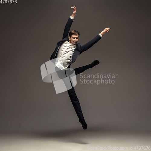 Image of Man in casual office style clothes jumping isolated on studio background