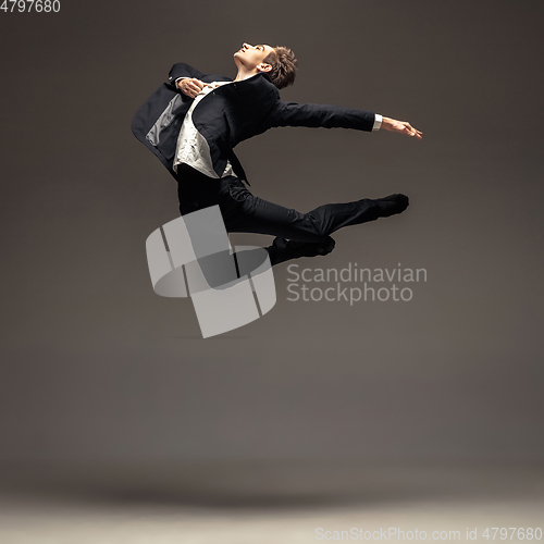 Image of Man in casual office style clothes jumping isolated on studio background