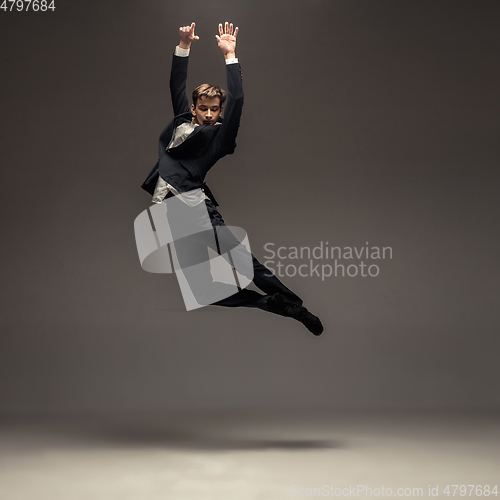 Image of Man in casual office style clothes jumping isolated on studio background