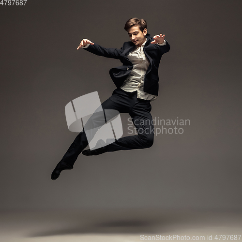 Image of Man in casual office style clothes jumping isolated on studio background