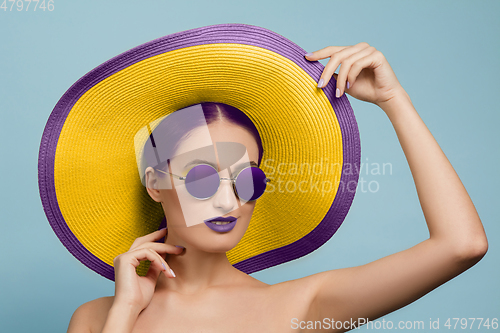 Image of Portrait of beautiful young woman with bright make-up isolated on blue studio background