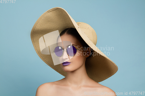 Image of Portrait of beautiful young woman with bright make-up isolated on blue studio background