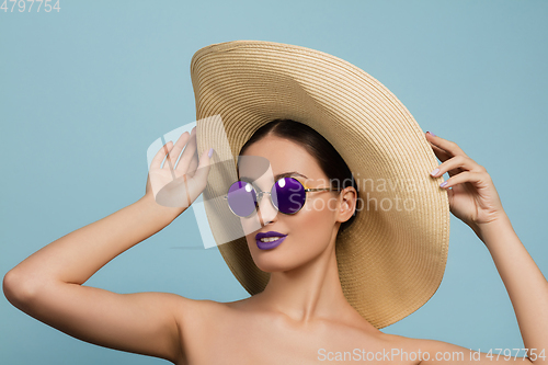 Image of Portrait of beautiful young woman with bright make-up isolated on blue studio background