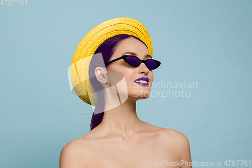 Image of Portrait of beautiful young woman with bright make-up isolated on blue studio background