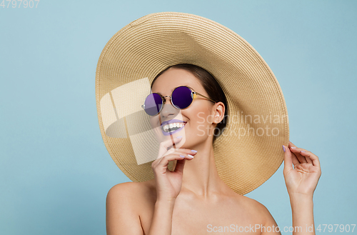 Image of Portrait of beautiful young woman with bright make-up isolated on blue studio background