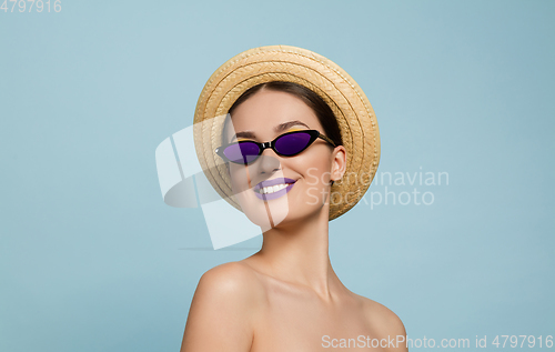 Image of Portrait of beautiful young woman with bright make-up isolated on blue studio background