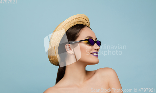 Image of Portrait of beautiful young woman with bright make-up isolated on blue studio background