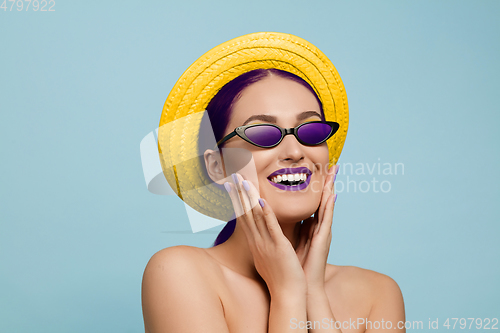 Image of Portrait of beautiful young woman with bright make-up isolated on blue studio background