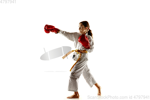 Image of Confident junior in kimono practicing hand-to-hand combat, martial arts