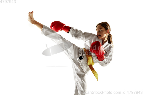 Image of Confident junior in kimono practicing hand-to-hand combat, martial arts