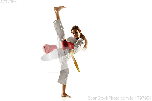 Image of Confident junior in kimono practicing hand-to-hand combat, martial arts