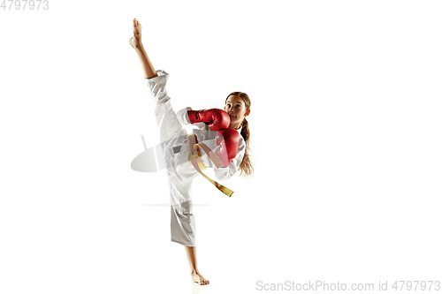 Image of Confident junior in kimono practicing hand-to-hand combat, martial arts