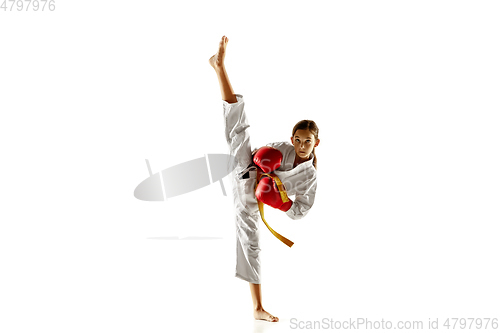 Image of Confident junior in kimono practicing hand-to-hand combat, martial arts