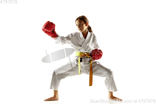 Image of Confident junior in kimono practicing hand-to-hand combat, martial arts