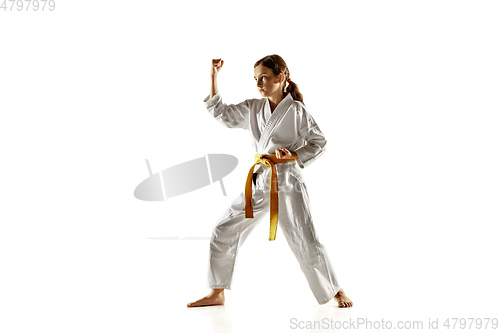 Image of Confident junior in kimono practicing hand-to-hand combat, martial arts