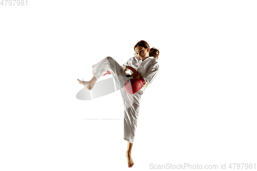 Image of Confident junior in kimono practicing hand-to-hand combat, martial arts