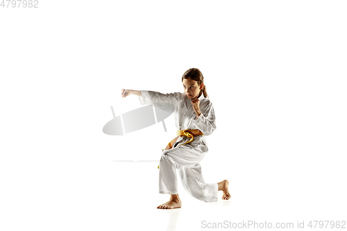 Image of Confident junior in kimono practicing hand-to-hand combat, martial arts