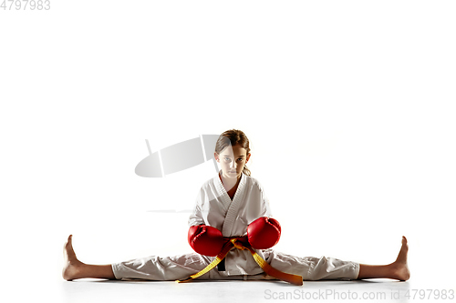 Image of Confident junior in kimono practicing hand-to-hand combat, martial arts