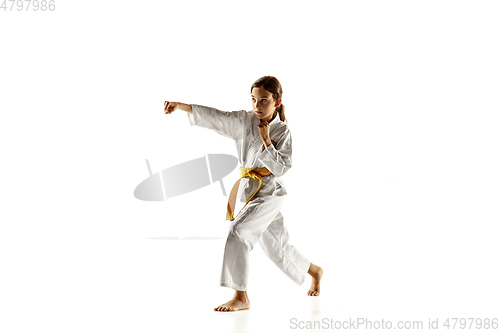 Image of Confident junior in kimono practicing hand-to-hand combat, martial arts