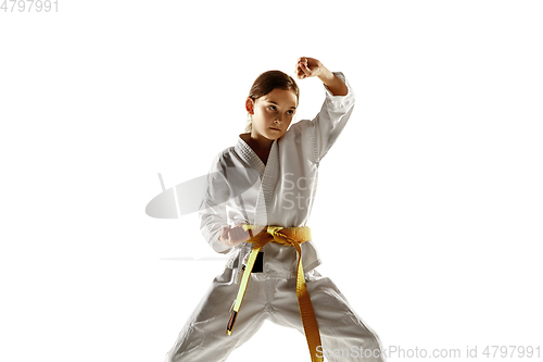 Image of Confident junior in kimono practicing hand-to-hand combat, martial arts