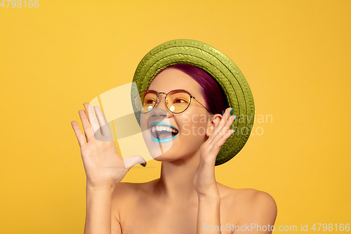 Image of Portrait of beautiful young woman with bright make-up isolated on yellow studio background