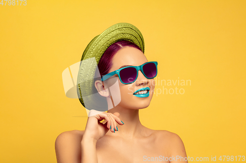 Image of Portrait of beautiful young woman with bright make-up isolated on yellow studio background