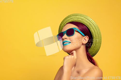 Image of Portrait of beautiful young woman with bright make-up isolated on yellow studio background