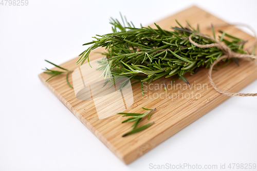 Image of bunch of rosemary on wooden cutting board