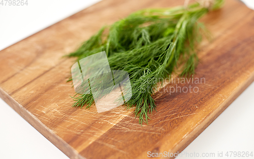 Image of bunch of dill on wooden cutting board