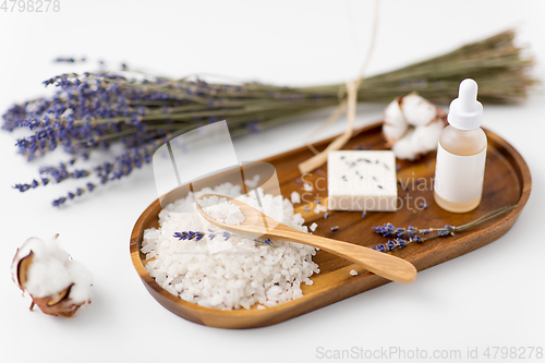 Image of sea salt, lavender soap and serum on wooden tray