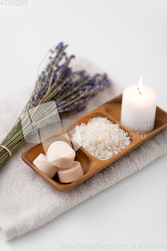 Image of sea salt, soap, candle and lavender on bath towel