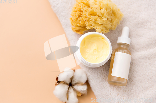 Image of body butter, essential oil, sponge on bath towel