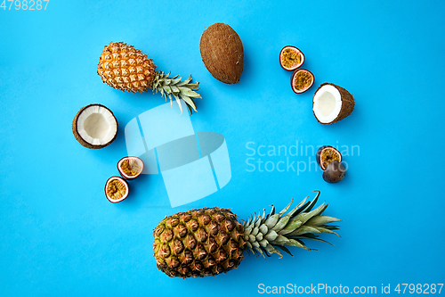 Image of pineapple, passion fruit and coconut on blue