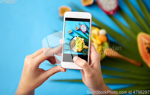 Image of hands taking photo of exotic fruits on smartphone