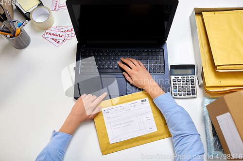 Image of hands with laptop and envelope at post office