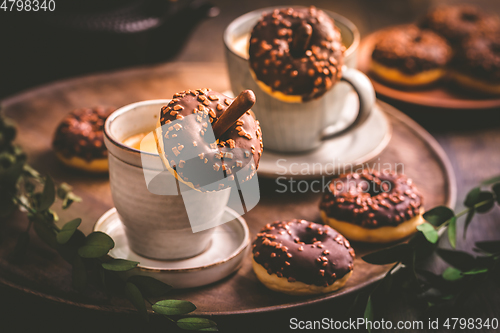 Image of Coffee time - two cups of Caffe Americano with small chocolate donuts