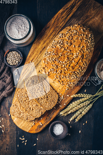 Image of Homemade wholemeal spelt bread with sunflower seeds and baking ingredients